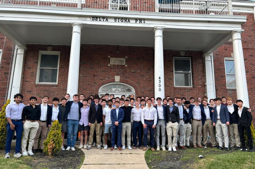 Members of Delta Sigma Phi in front of their chapter house