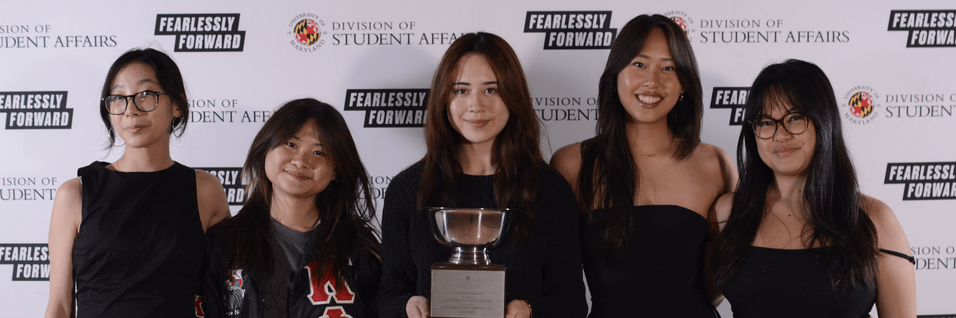 Group of women standing together holding a trophy