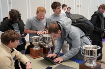 Men standing around a computer